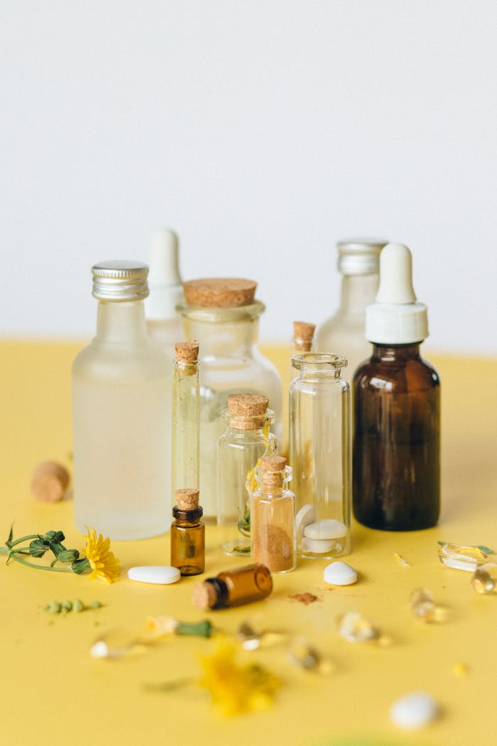 A collection of glass bottles with natural herbal medicines on a yellow background.